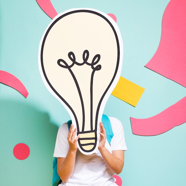 Portrait of schoolgirl with big light bulb