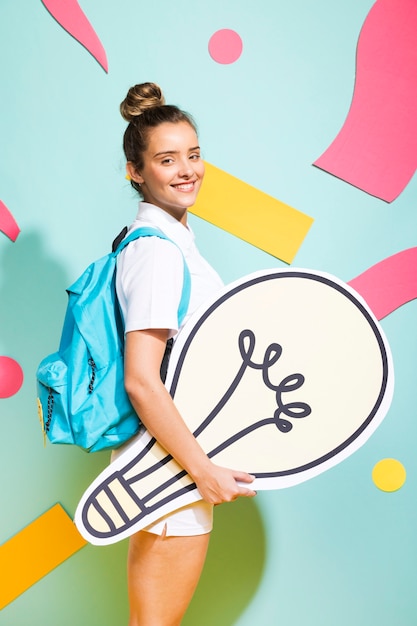 Portrait of schoolgirl with big light bulb