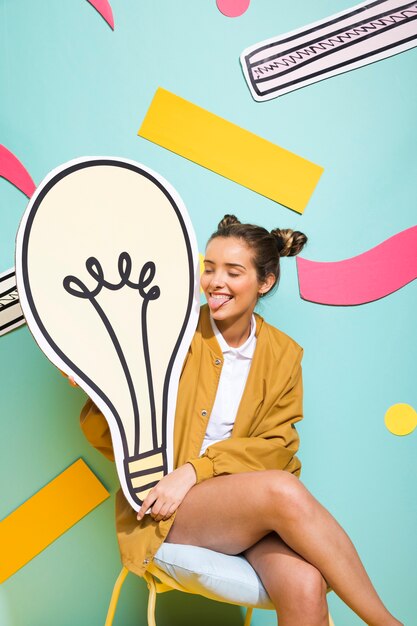 Portrait of schoolgirl with big light bulb