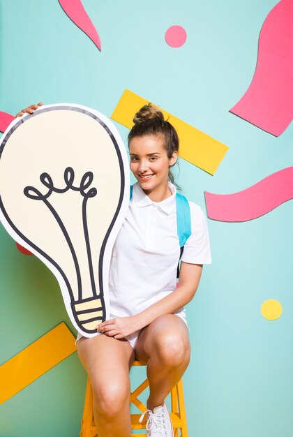 Portrait of schoolgirl with big light bulb