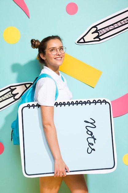 Free photo portrait of schoolgirl with big notepad template