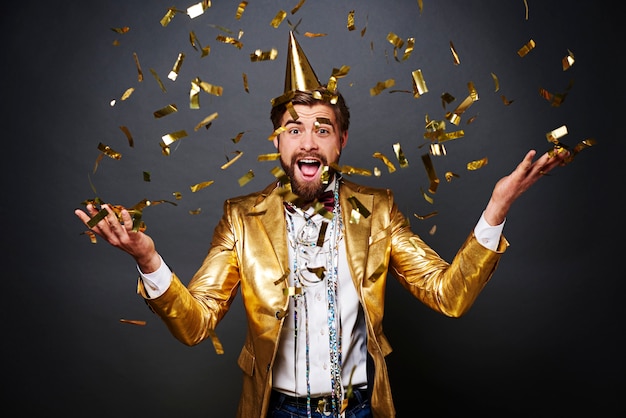 Portrait of Screaming man throwing confetti

