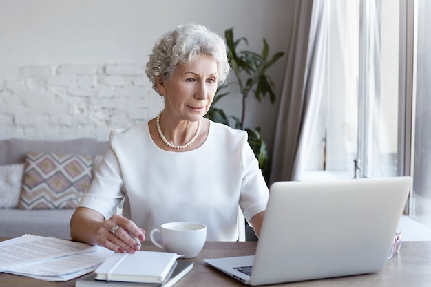 A portrait of senior businesswoman working indoor