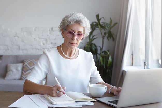 A portrait of senior businesswoman working indoor