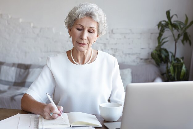 A portrait of senior businesswoman working indoor