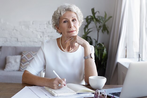 A portrait of senior businesswoman working indoor