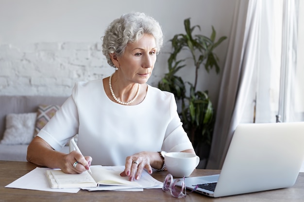 A portrait of senior businesswoman working indoor