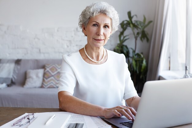 A portrait of senior businesswoman working indoor