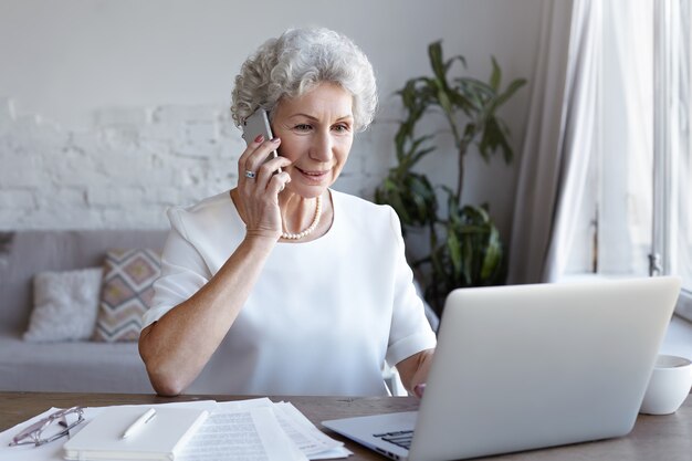 A portrait of senior businesswoman working indoor