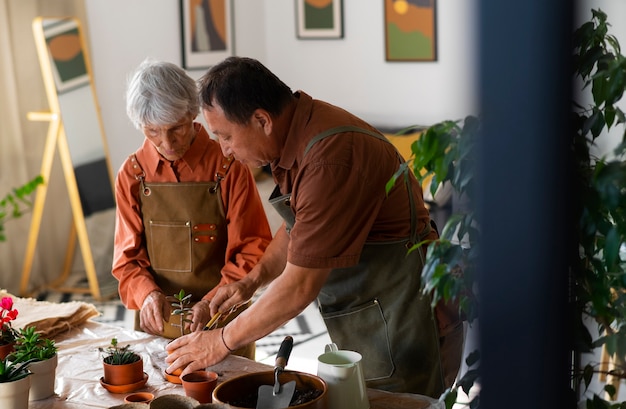 Free photo portrait of senior couple repotting plants at home