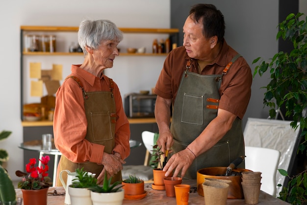 Free photo portrait of senior couple repotting plants at home