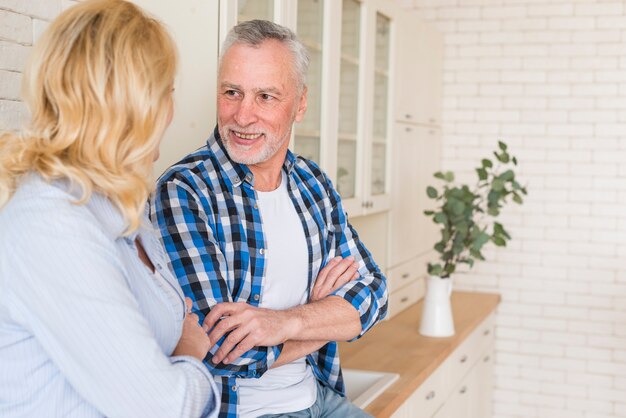 Portrait of a senior couple with their arms crossed looking at each other