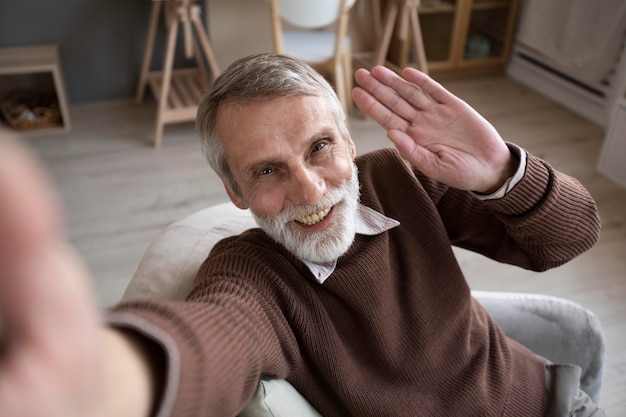 Portrait of senior male waiving at camera