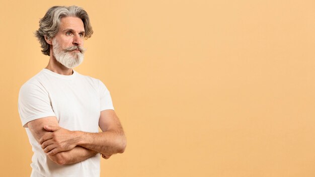 Portrait of senior man crossing arms with copy-space