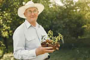 Free photo portrait of senior man in a hat gardening