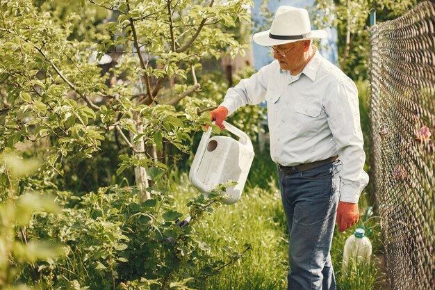 Portrait of senior man in a hat gardening