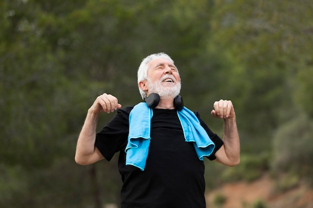 Free photo portrait senior man jogging on mountain