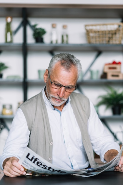 Free photo portrait of senior man reading newspaper