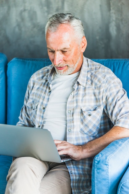 Портрет старшего человека, используя ноутбук