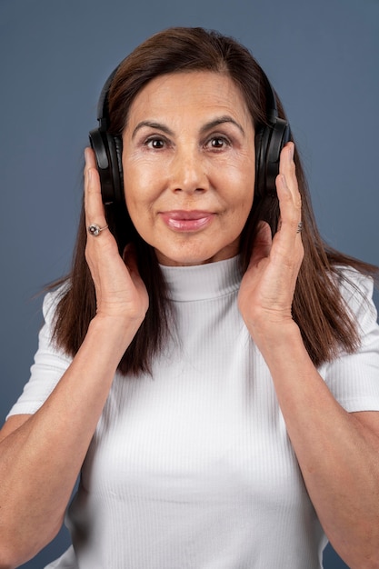 Free photo portrait of senior woman listening to music though headphones