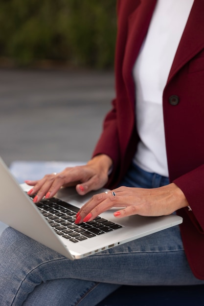 Portrait of senior woman in professional blazer outdoors and laptop