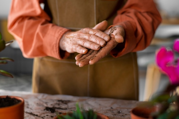 Free photo portrait of senior woman repotting plants at home