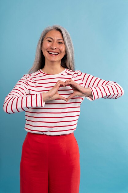 Portrait of senior woman showing the heart hands