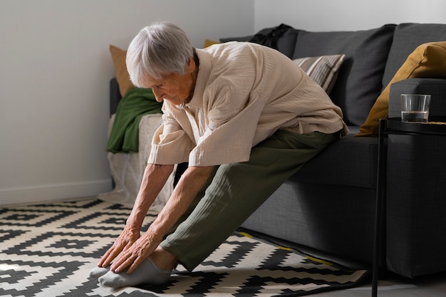 Free photo portrait of senior woman stretching at home