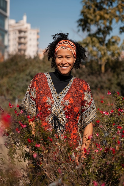 Foto gratuita ritratto di donna anziana con fiori all'aperto