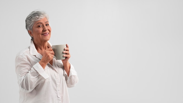 Free photo portrait of senior woman with mug