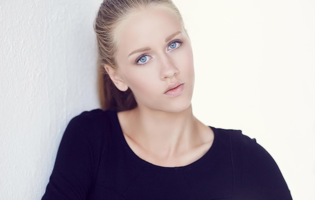 Portrait of sensual blond female in black dress.