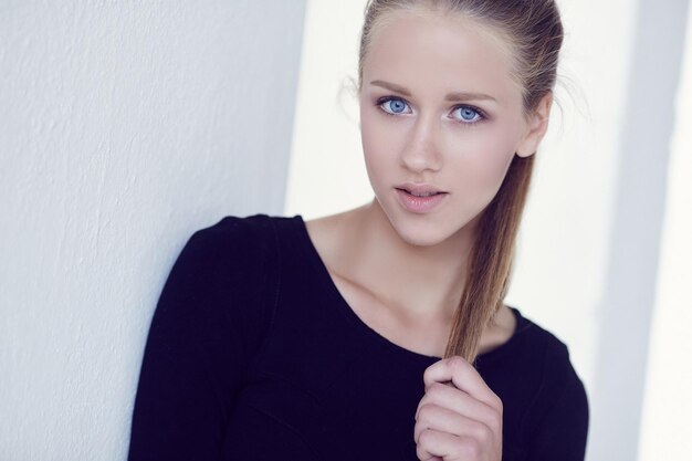 Portrait of sensual blond female in black dress.