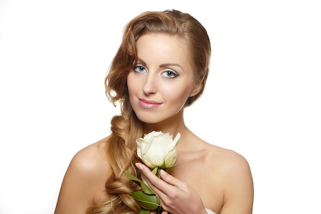 Portrait of sensual smiling beautiful woman with white rose on white 