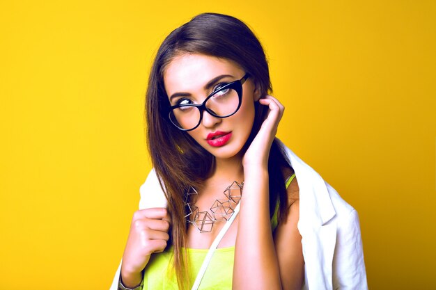 portrait of sensual young woman , long brunette hairs, retro glasses, business bright casual look