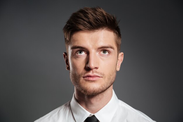 Portrait of a serious attractive man in shirt looking up