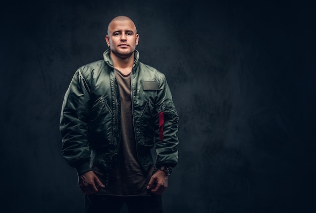 portrait of a serious brutal male in casual clothes on a dark background.