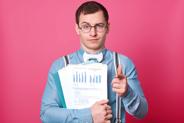 Portrait of serious business man with documents in hands