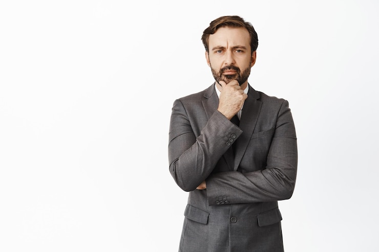 Free Photo portrait of serious businessman touching his beard frowning and thinking making important decision ponder standing over white background