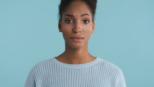 Portrait of serious casual african american girl confusedly looking in camera over colorful background