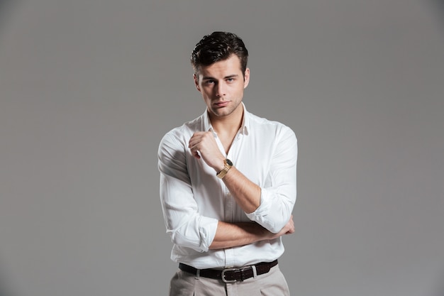 Portrait of a serious concentrated man in white shirt