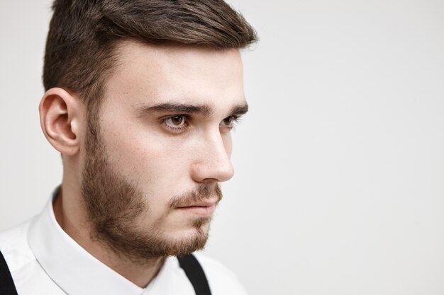 Portrait of serious concentrated young manager with bristle looking ahead of him with focused determined facial expression, ready for hard work. Job, career, competition and challenge concept