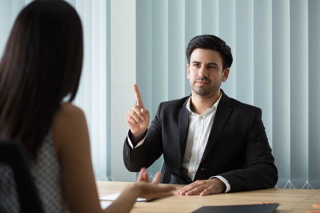 Portrait of serious executive explaining tasks to employee