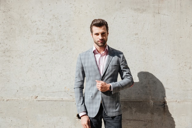 Portrait of a serious handsome man in a jacket standing