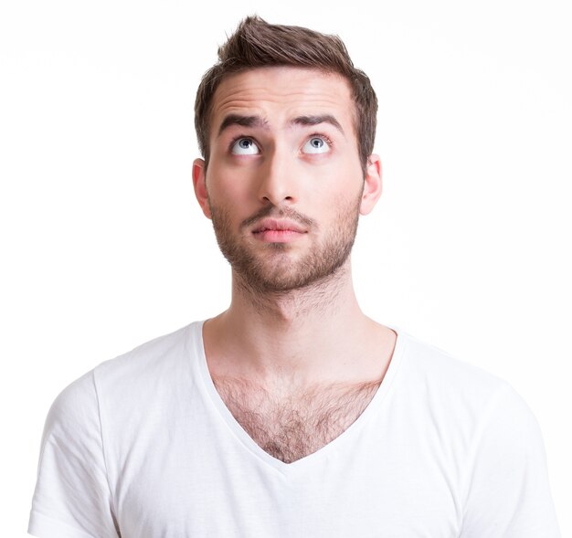 Portrait of serious handsome young man looking up - isolated on white.