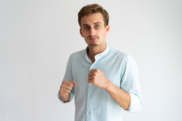 Portrait of serious upset guy ready for fight. 