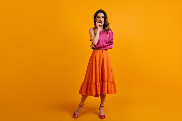 Portrait of serious woman wears long orange skirt
