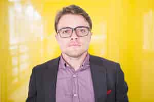 Free photo portrait of serious young businessman in glasses