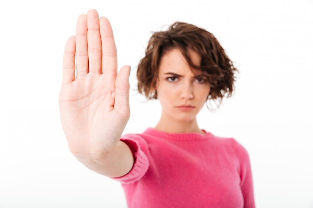 Portrait of a serious young girl showing stop gesture