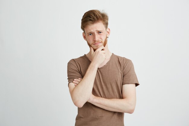 Portrait of serious young man thinking considering.