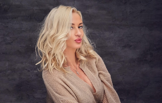 Portrait of sexual blond female with curly hair over grey background.